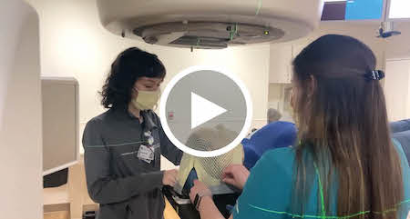 Radiation therapists helping a patient - play screen